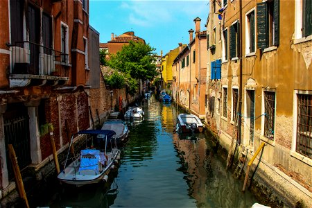 Boats Docked In Canal Between Buildings photo