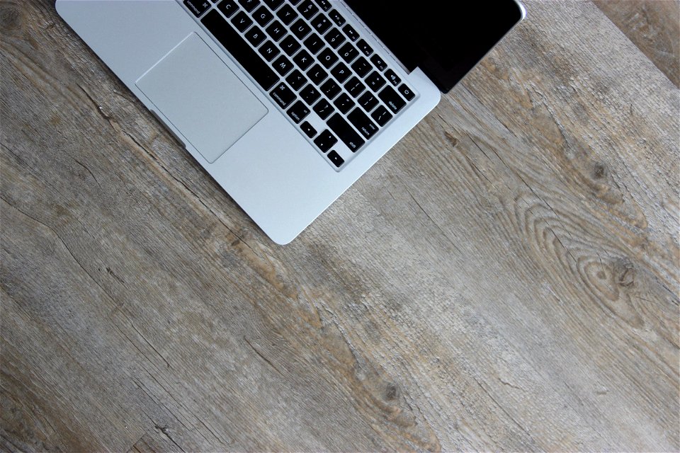 Part of Laptop Computer on Light Wood Desk