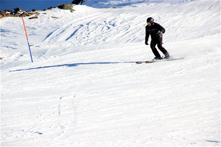 Man Skiing Down Snow Slopes photo
