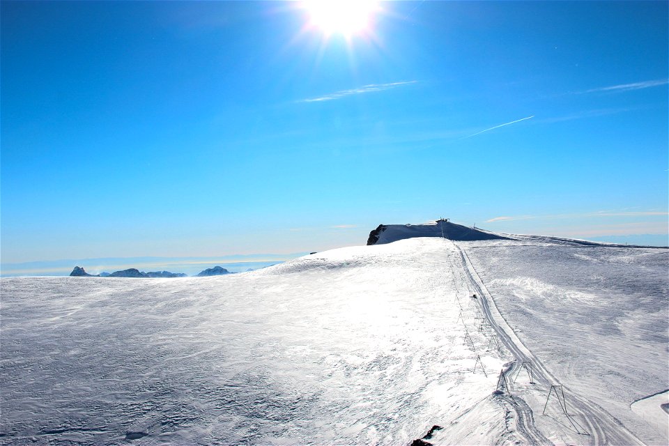 Sun Over Snow Plain in Mountains photo