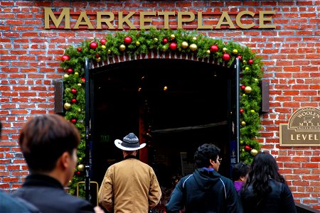 People Walking into Christmas Decorated Marketplace Building photo
