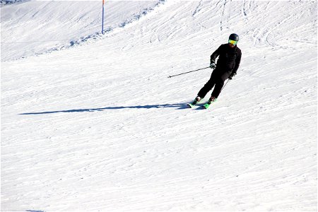 Man Skiing Down Snow Slope photo