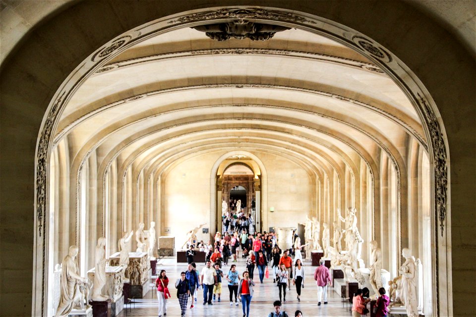 People in Museum Hallway with Statues photo