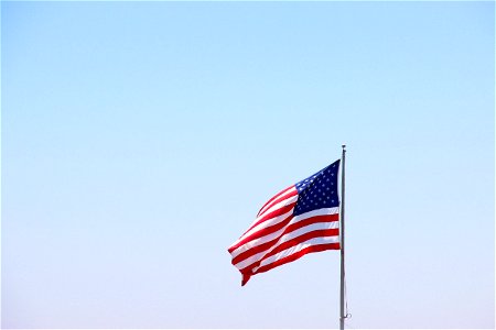 American Flag Waving in Clear Sky photo