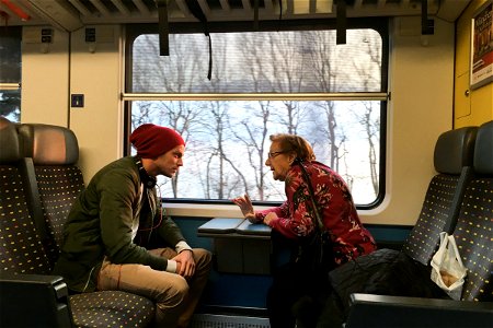Young Man & Old Woman Talking on Train photo