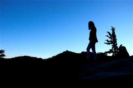 Silhouette of Woman Standing on Mountain photo