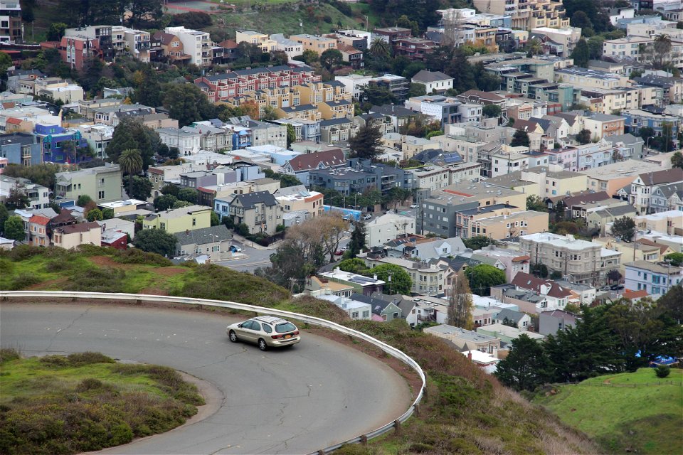 Car Driving Around Winding Road by Houses photo