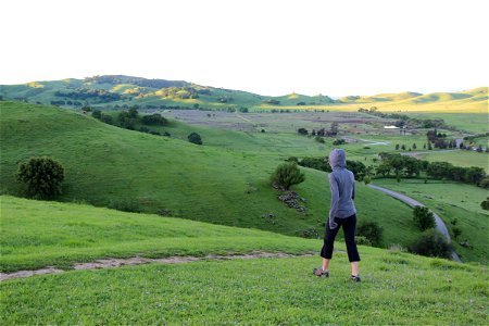 Woman in Grey Hoodie Walking on Hills photo
