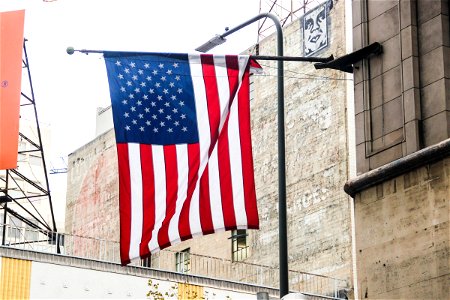 American Flag Hanging on Side of Brick Building photo