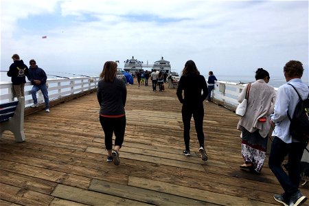 People Walking on Wooden Pier at Ocean photo