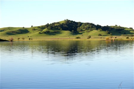 Still Lake in Front of Green Hills