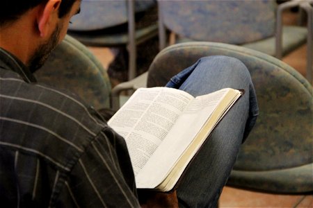 Man Reading Bible in His Lap photo