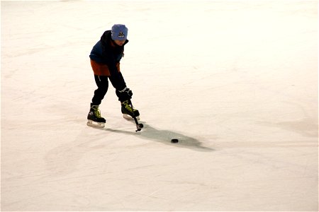 Boy on Ice About to Hit Hockey Puck.jpg