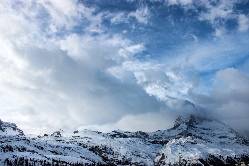 Clouds Over Snow Covered Mountain Tops photo