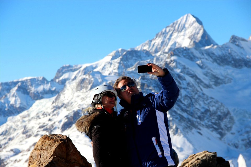 Couple Taking Selfie in Front of Snow-Covered Mountains photo