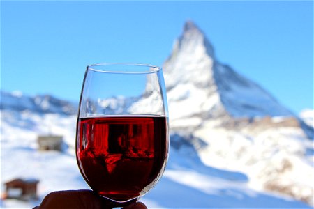 Glass of Red Wine with Snowy Mountain in Background photo