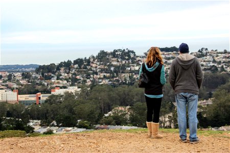 Couple Standing on Hill Looking at City photo
