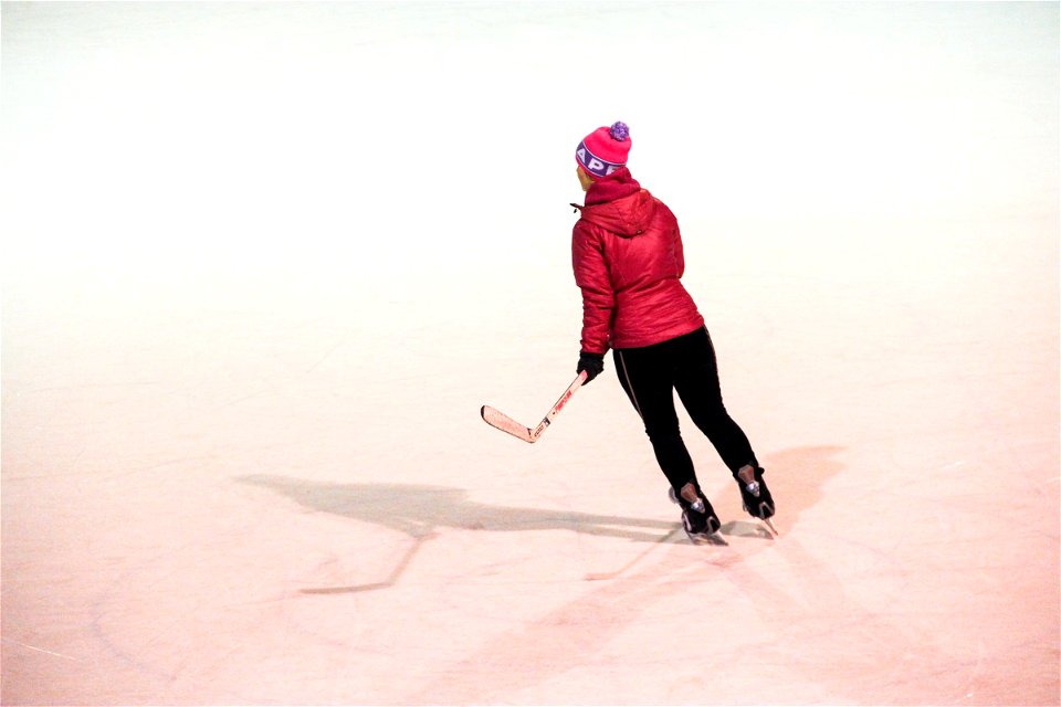 Girl with Hockey Stick Skating on Ice