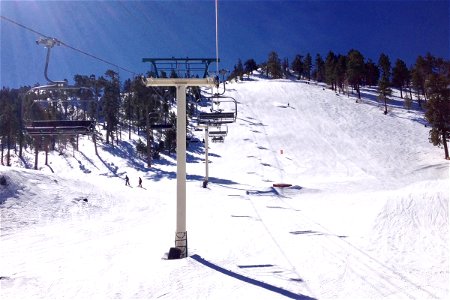 Ski Lift Going Up Snow Covered Mountain photo
