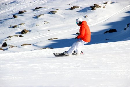 Snowboarder Riding on Slopes photo