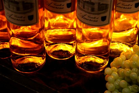 Yellow Bottles of Wine Next to Grapes photo