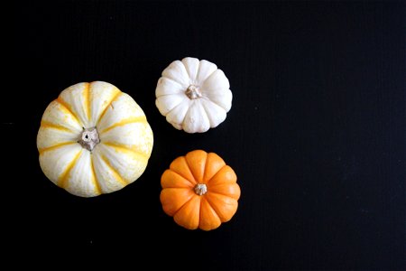 3 Small Pumpkins on Dark Table photo