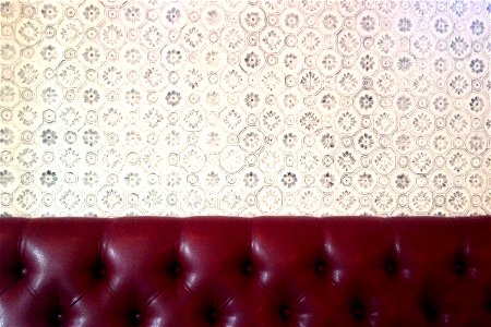 Red Vinyl Seat on Patterned Wallpaper photo