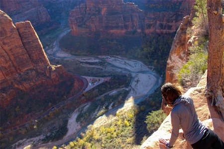 Woman on Edge of Cliff Overlooking Valley photo