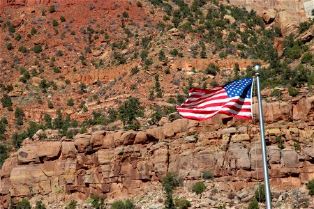 American Flag Waving in Front of Rocky Cliffs photo