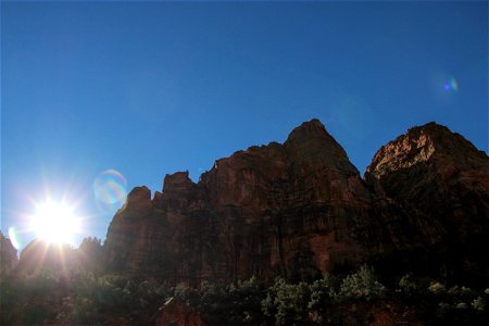 Sun Rising Over Rock Mountains on a Clear Sky photo