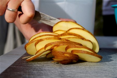 Knife Cutting Potato Slices photo