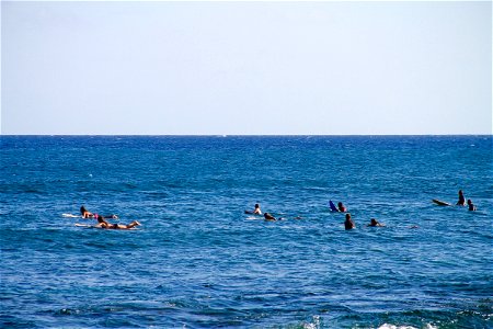 People on Surf Boards Paddling in Ocean photo