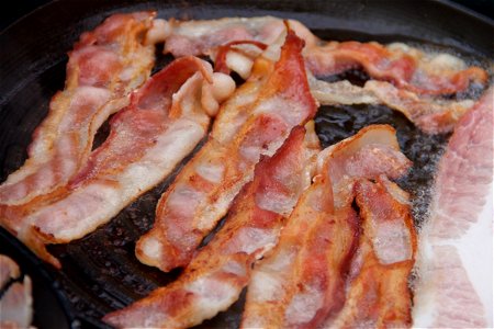 Bacon Strips Cooking in Frying Pan photo
