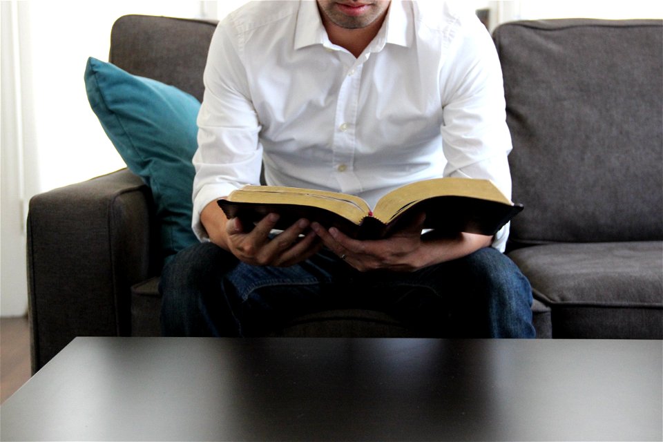 Man on Couch Reading Bible photo