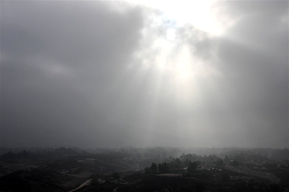 Sunlight Shining Through Thick Clouds Over Hazy Town photo