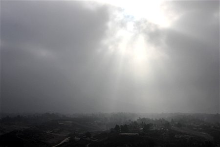 Sunlight Shining Through Thick Clouds Over Hazy Town