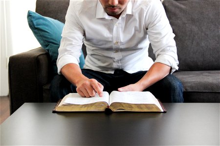 Man on Couch Reading Bible photo