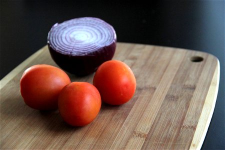 Tomatoes & Red Onion on Wood Cutting Board photo