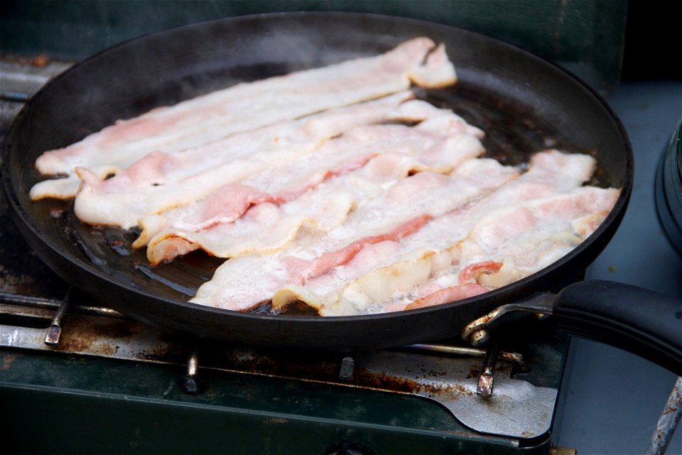 Strips of Bacon Cooking on a Skillet photo