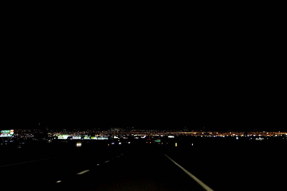 Dark Street Leading to City Lights at Night