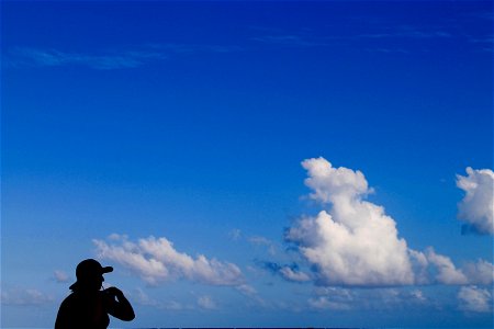 Silhouette of Woman on Blue Sky with Clouds photo