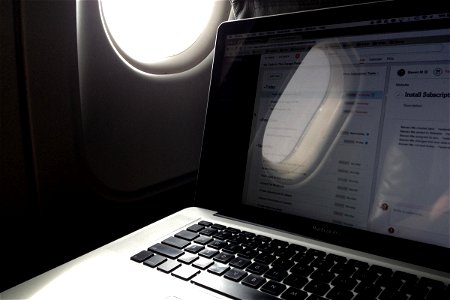 Laptop Next to Airplane Window photo