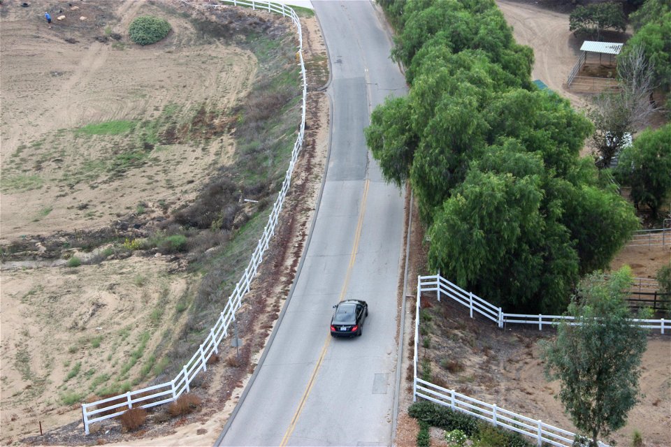 Black Car Driving Down Road Through Country