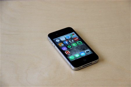 Black iPhone on Home Screen on Light Wood