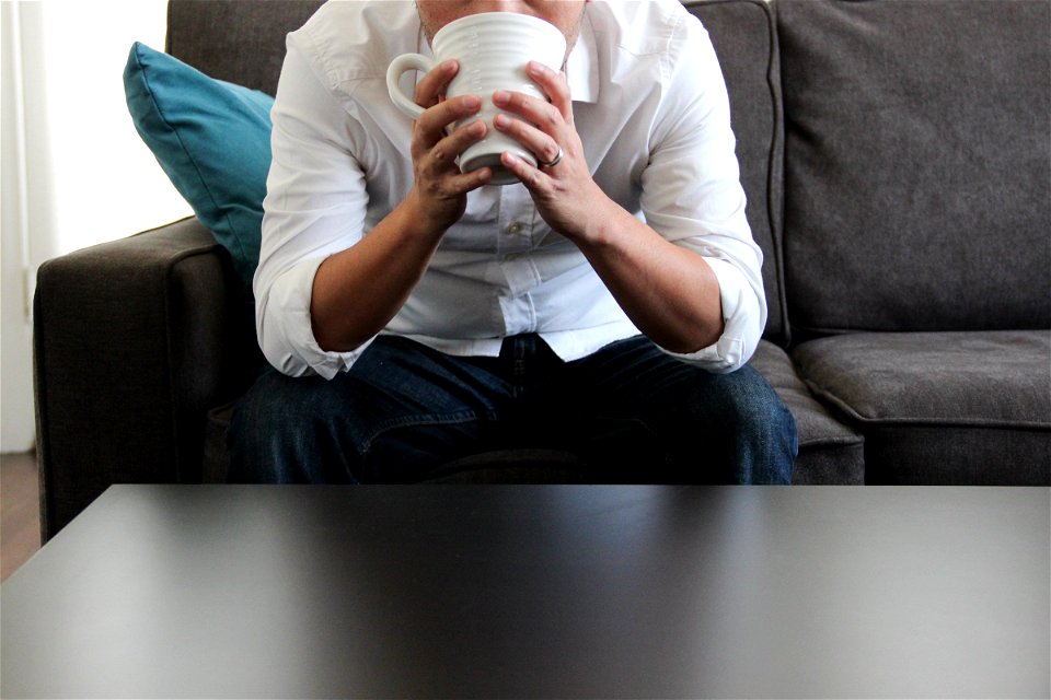 Man on Couch Drinking From Mug photo