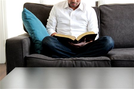 Man on Couch Reading Bible photo