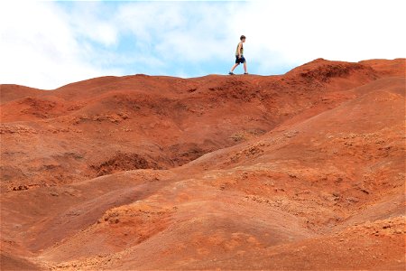 Boy Walking on Red Dirt Hills photo