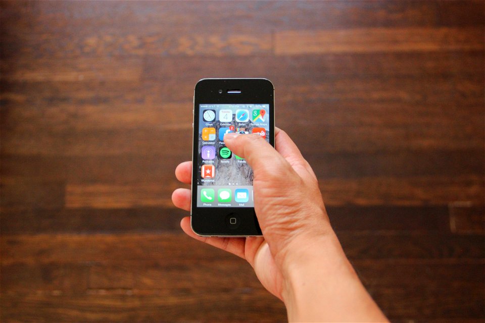Hand Holding iPhone 4 Selecting Facebook App