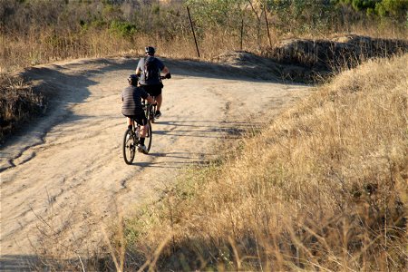 2 Bicyclists Riding on Dirt Trail photo