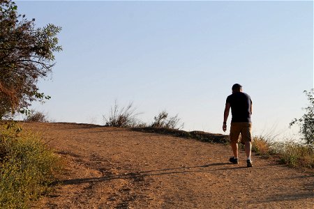 Man Walking Up a Dirt Trail photo